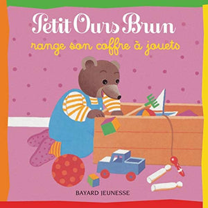 Petit ours brun range son coffre à jouets